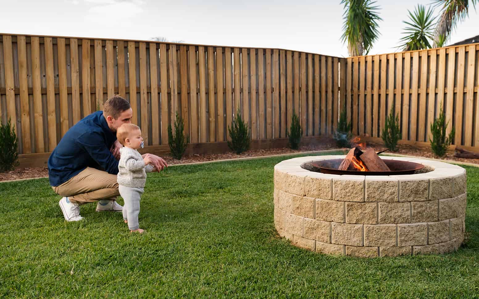 a person and baby by a fire pit